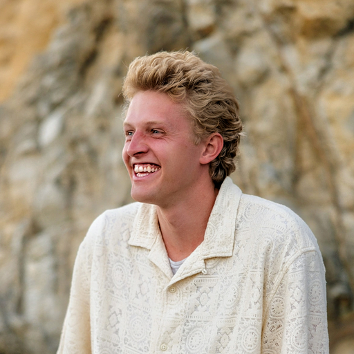 aroet Hale Headshot. The background features a rocky outdoor setting, suggesting a natural environment like a cliff or mountainside.
